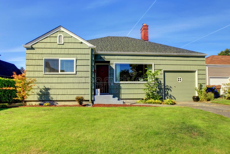 Simple one story small green house with garage door. Simple one story small green house with garage door.