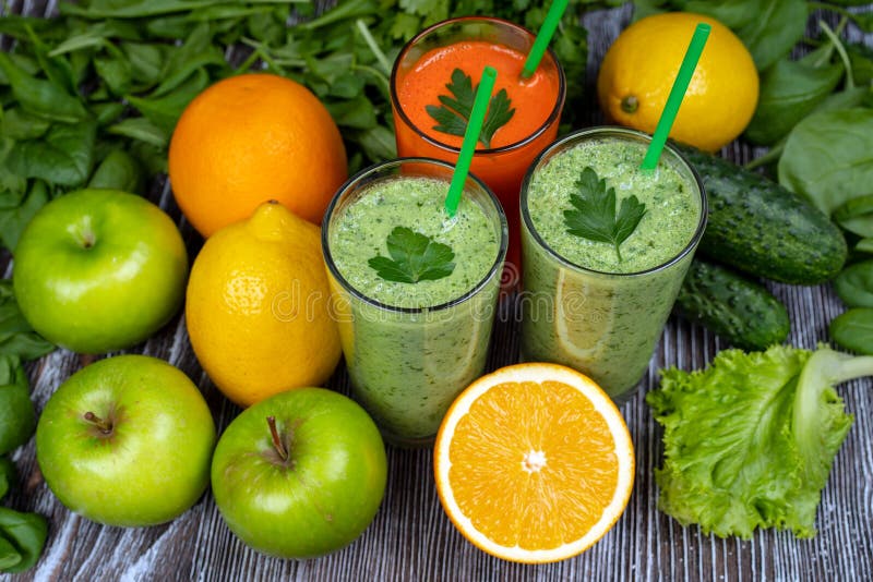 Green smoothie, carrot juice and multicolored fruit, green Apple, cucumber, spinach, lemon, orange, salad, cilantro