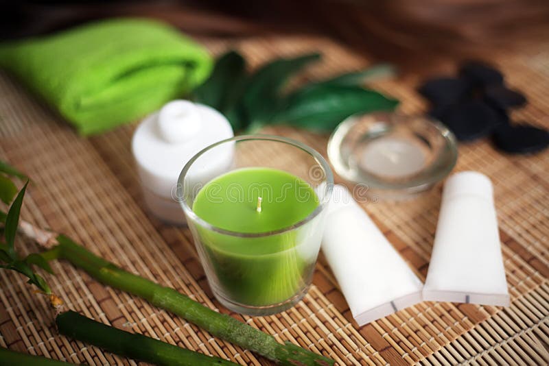 Green Spa tools with candle and towel on wood