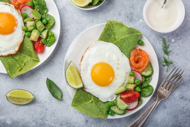 Green Spinach Crepes with Fried Eggs, Smoked Salmon and Vegetables for