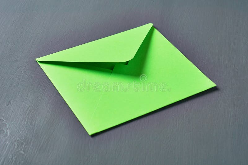 Green square paper envelope lies on scratched dark concrete stock image Green square paper envelope lies on scratched dark concrete stock image