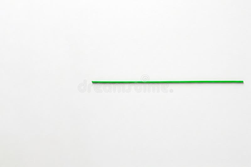A green stick on a clean light background. Space for text. stock photos