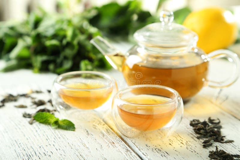 Green Tea in Cup and Teapot on White Wooden Background Stock Image