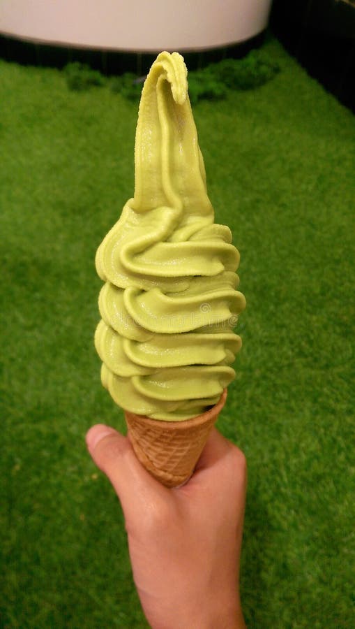 Green tea ice cream cone in hand