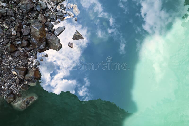 green turquoise water and reflections of the sky in it. natural natural background. rocks and clouds, reflection of