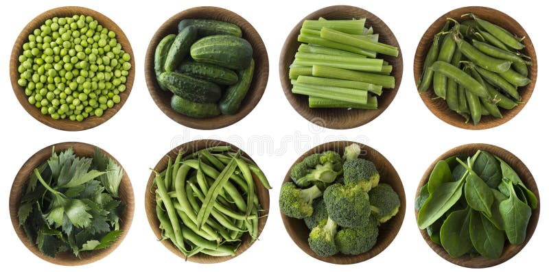 Green vegetables isolated on a white background. Brocoli, green peas, cucumbers and leaves parsley, celery, spinach in wooden bowl