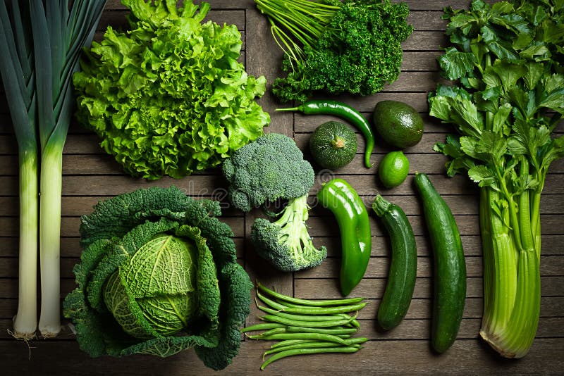 Set di stagione verdure verdi sparsi in una composizione di un tavolo di legno.