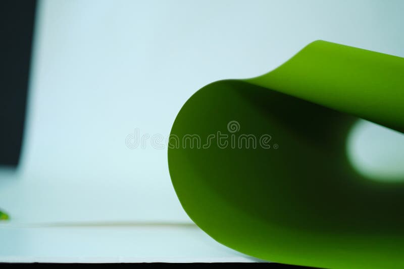 Green wave from paper on white background with copy space. Concepts: lines and geometry. defocus abstract background.