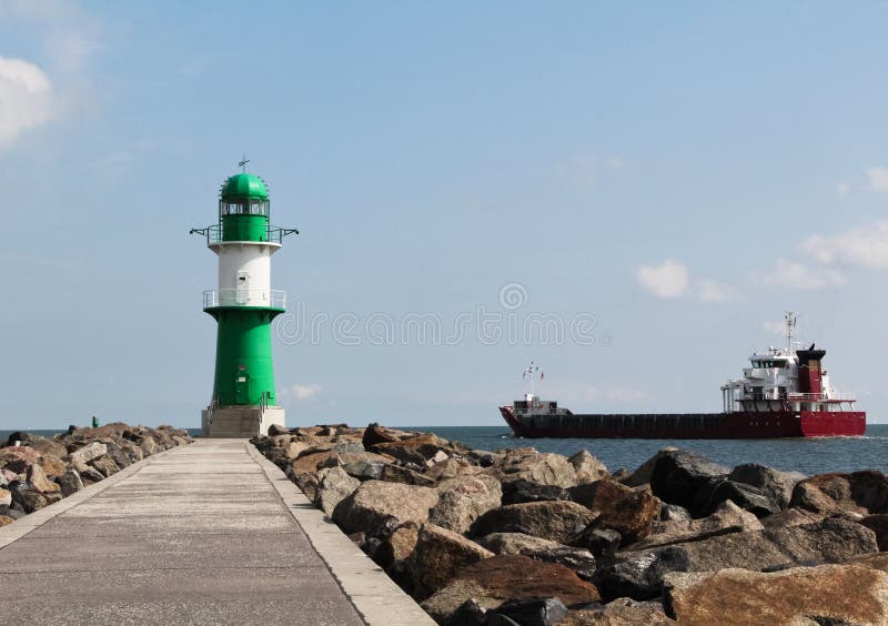 Green And White Lighthouse And Cargo Ship Leaving Port Stock Photo Image of commercial, cargo