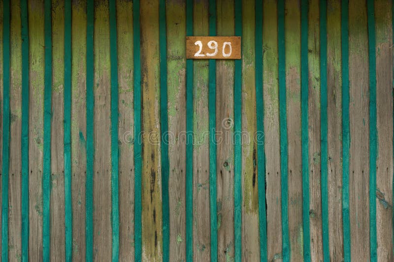 the number 14 in red on a rustic yellow boat shed door