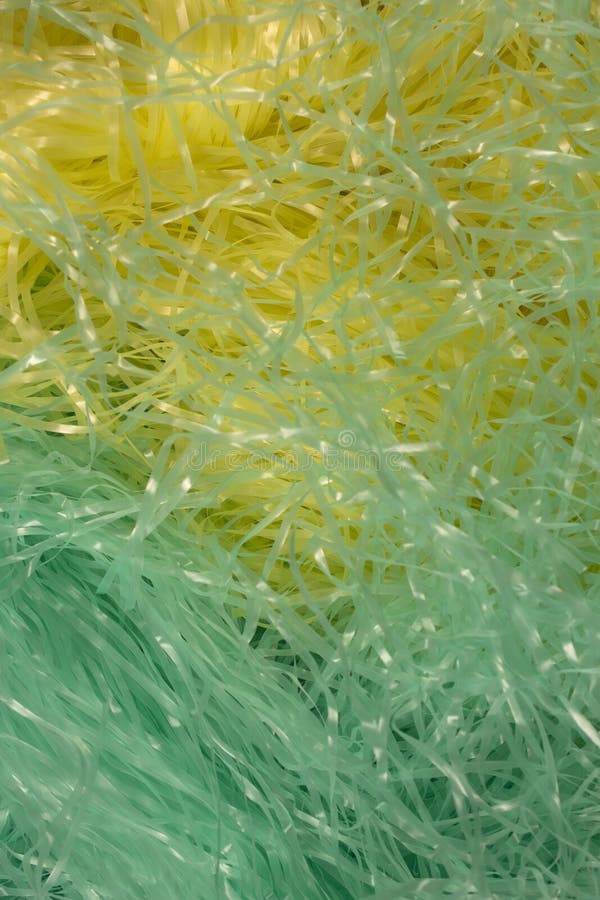 Green and Yellow Shredded Plastic Fake Easter Grass Background Stock