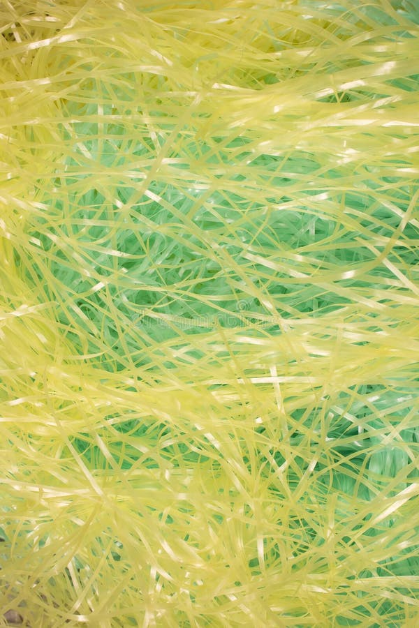 Green and Yellow Shredded Plastic Fake Easter Grass Background Stock