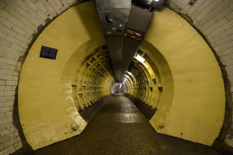 London, UK - 6/15/19 - A foot tunnel leading under the Thames river in London - UK. London, UK - 6/15/19 - A foot tunnel leading under the Thames river in London - UK