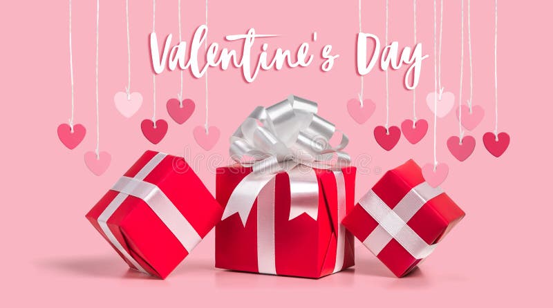 Greeting card for Valentine&x27;s Day. Red hearts, gift boxes on a pink background