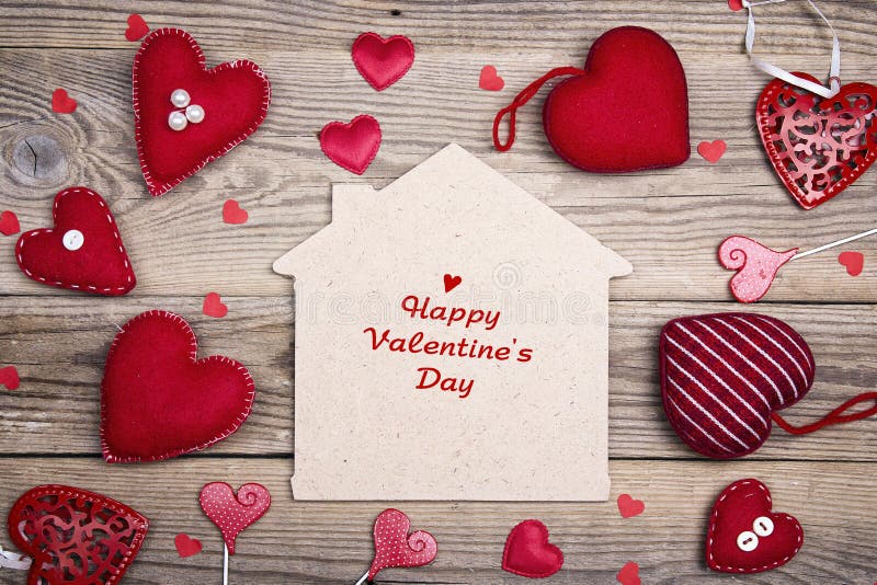 Greeting Valentines Day card with home symbol and red hearts on wooden background. Happy Valentine`s Day.