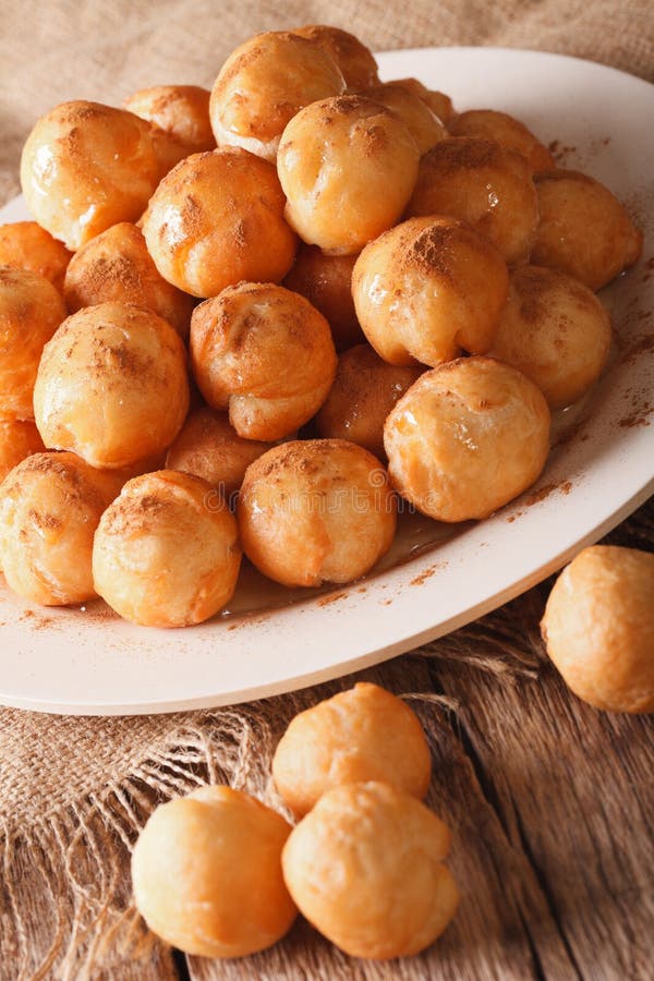 Grekiska loukoumadesdonuts med honung- och kanelcloseupen royaltyfri fotografi Grekiska loukoumadesdonuts med honung- och kanelcloseupen royaltyfri fotografi
