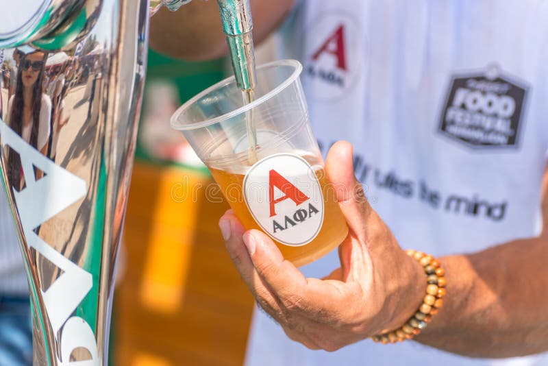 Grekland, Heraklion - 15 september: En man som häller glas öl Matfest på gatan arkivbilder Grekland, Heraklion - 15 september: En man som häller glas öl Matfest på gatan arkivbilder