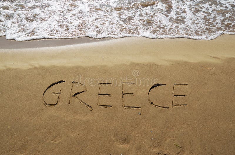 Grekland som är skriftlig i sand arkivbild Grekland som är skriftlig i sand arkivbild