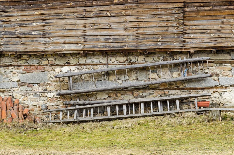 Grenier à foin antique avec le mur en pierre de dessous, planche en bois de ci-dessus et chariot-échelle dans le mur, Koprivshtit image stock Grenier à foin antique avec le mur en pierre de dessous, planche en bois de ci-dessus et chariot-échelle dans le mur, Koprivshtit image stock