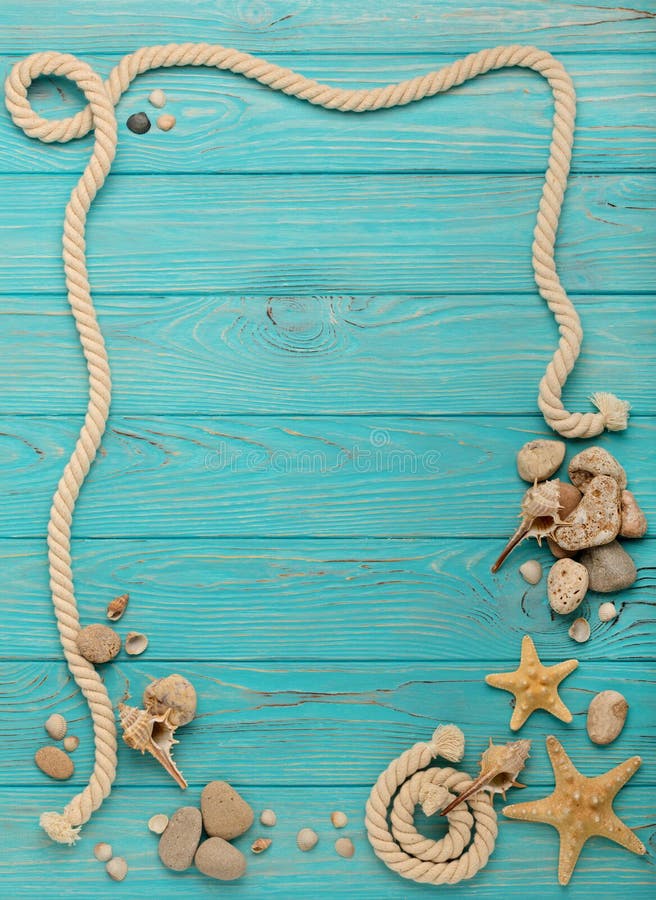 Border with rope, stones, sea shells and starfish on a turquoise wooden background. Top view. Border with rope, stones, sea shells and starfish on a turquoise wooden background. Top view.