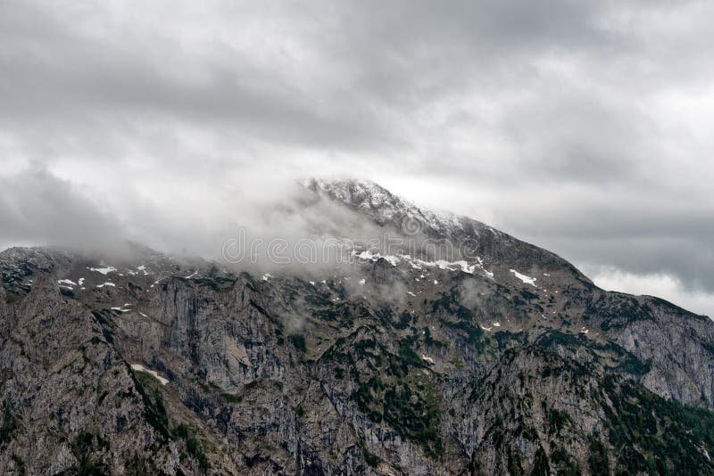 Grey clouds over a steep mountain peak