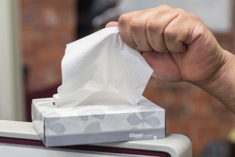 Box of kleenex tissue with branding on box with hand pulling one out