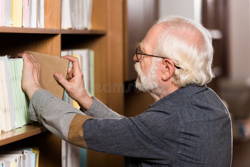 grey hair librarian taking book stock photos grey hair librarian taking book stock photos