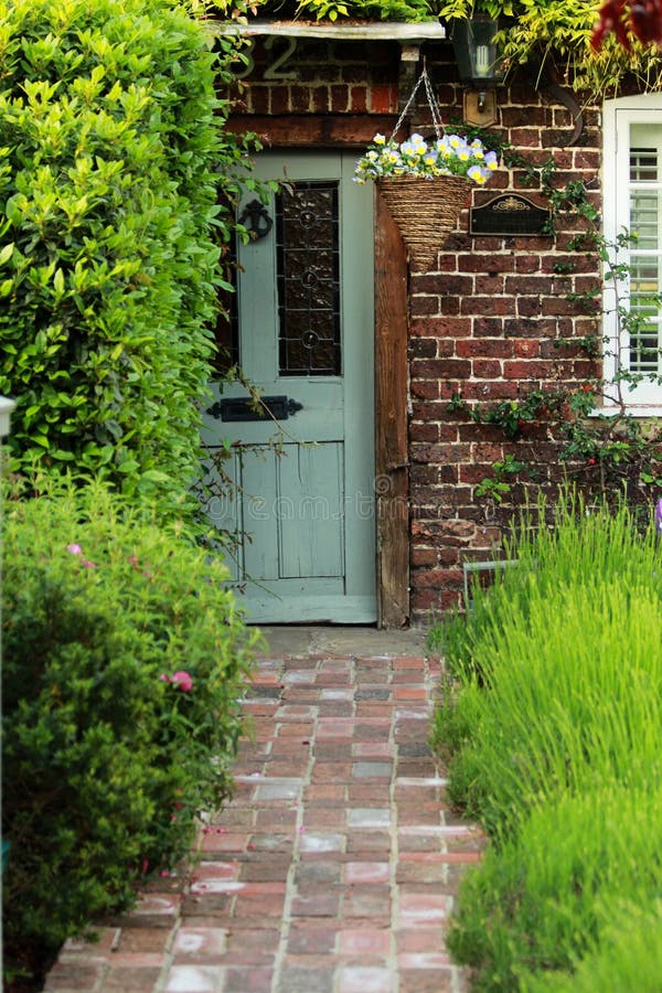 Grey Old Door With Orange Bricky Wall and Green Lavender Garden