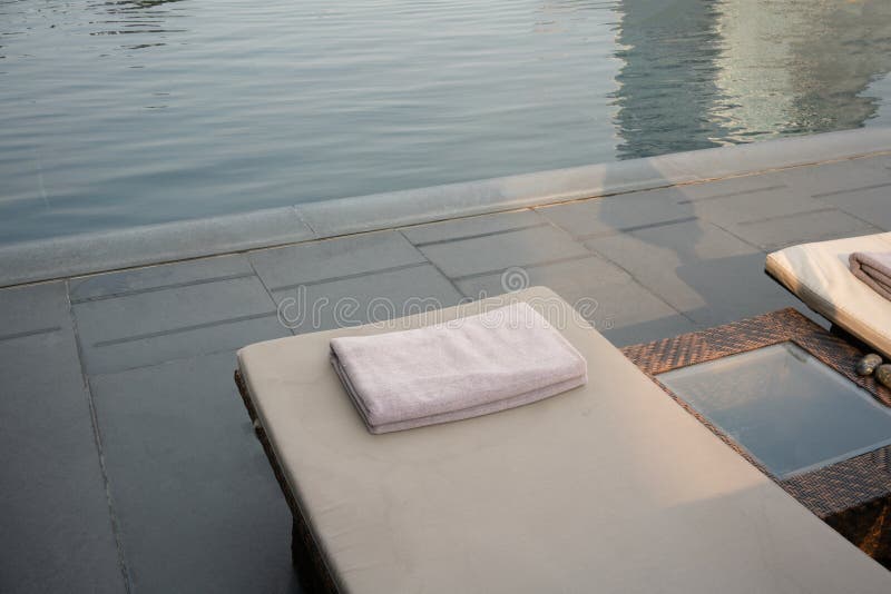 Grey Towel na cama de relaxamento da associação ao lado da piscina fotos de stock royalty free Grey Towel na cama de relaxamento da associação ao lado da piscina fotos de stock royalty free