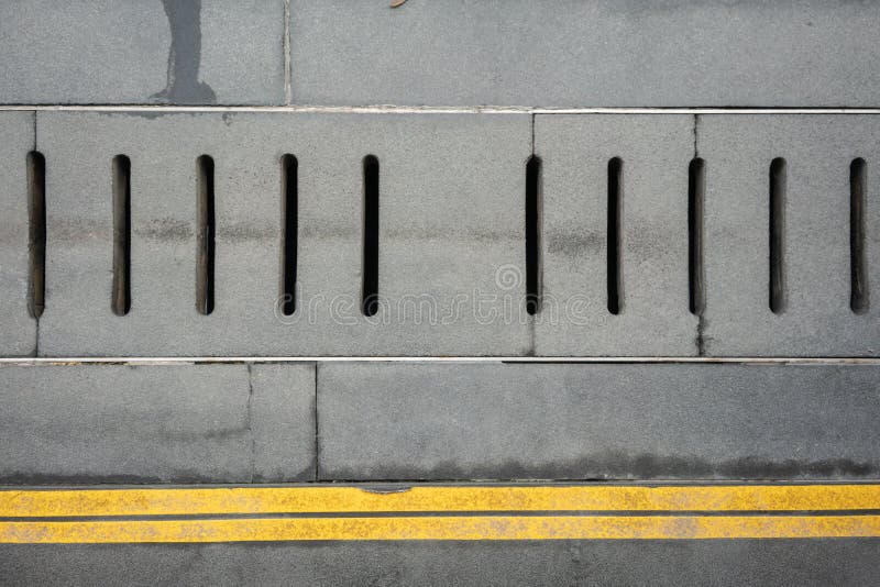 Grey water drainage cover on the concrete floor with double yellow lines royalty free stock photography Grey water drainage cover on the concrete floor with double yellow lines royalty free stock photography