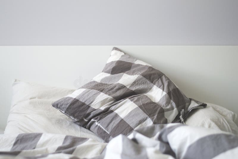 Grey and white pillows on a bed stock image Grey and white pillows on a bed stock image