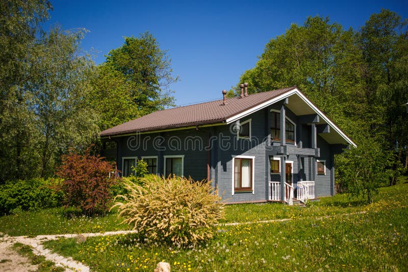 Grey wooden holiday home in a picturesque forest eco-Park. Cozy road to a country house in