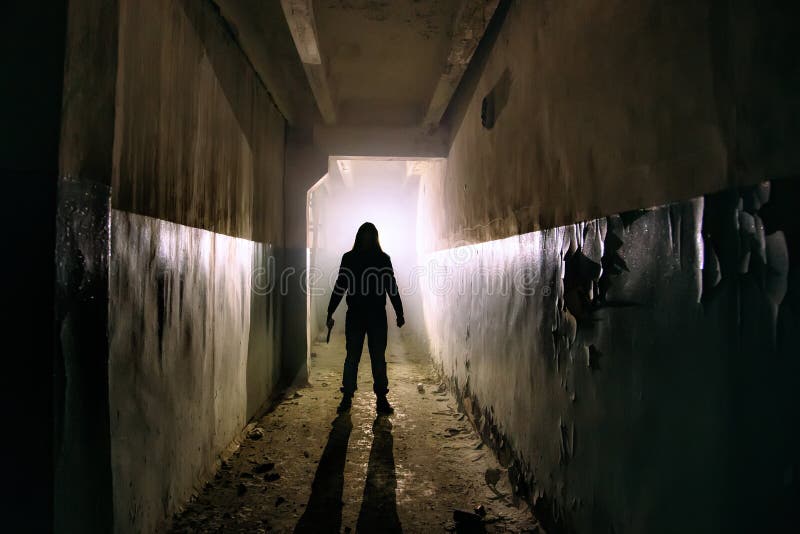 Creepy silhouette of unknown man with knife in dark abandoned building. Horror about maniac concept . Creepy silhouette of unknown man with knife in dark abandoned building. Horror about maniac concept .