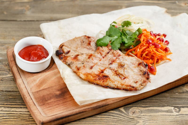 Pork steak grill. Serving on a wooden Board on a rustic table. Barbecue restaurant menu, a series of photos of different meats. food to beer. Pork steak grill. Serving on a wooden Board on a rustic table. Barbecue restaurant menu, a series of photos of different meats. food to beer