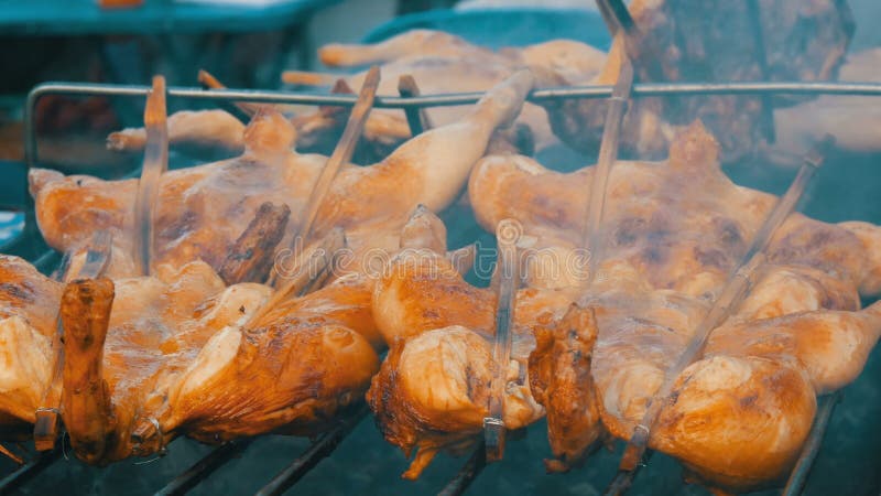 Griglia della carcassa dell'intero pollo messa insieme sul bastone di legno che griglia sulla griglia Alimento Tailandia della vi