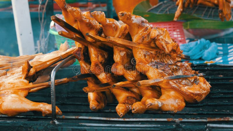 Griglia della carcassa dell'intero pollo messa insieme sul bastone di legno che griglia sulla griglia Alimento Tailandia della vi