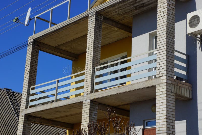 Grijze balkonportiek van raad en bakstenen op de voorgevel van het huis stock afbeelding Grijze balkonportiek van raad en bakstenen op de voorgevel van het huis stock afbeelding