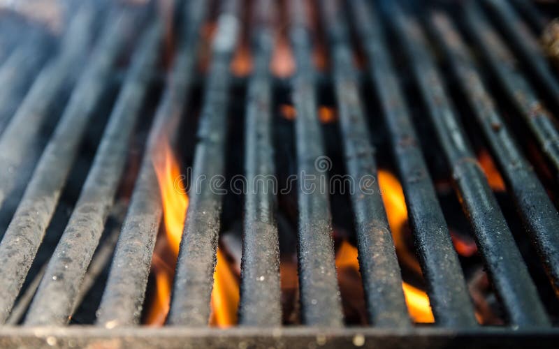 Grill bbq close up and bright hot flames, outside summer cookout, empty barbecue burning wood with smoke, blurred fire and charcoa