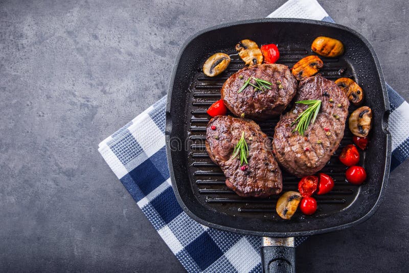 Grill beef steak. Portions thick beef juicy sirloin steaks on grill teflon pan or old wooden board