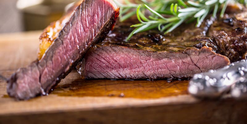 Grill juicy beef T-bone steak with salt pepper and rosemary