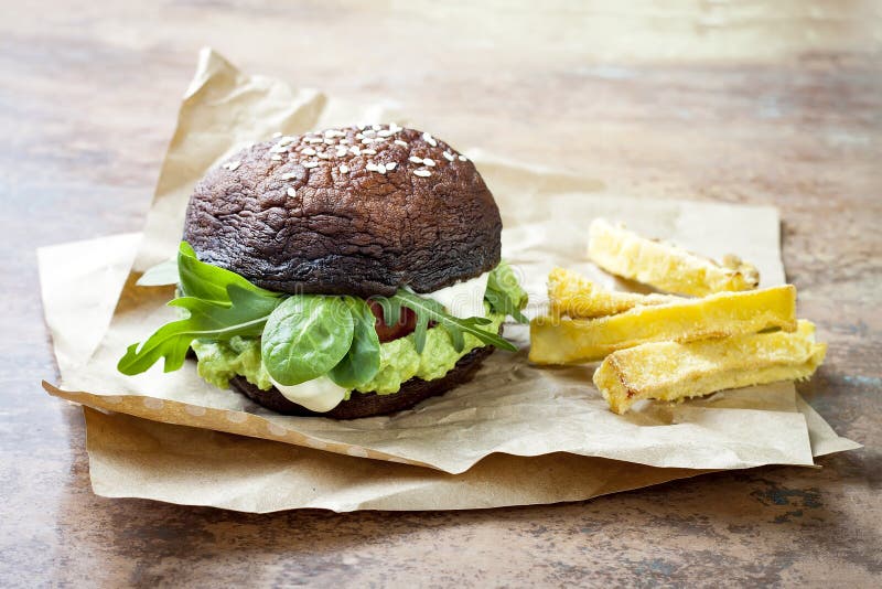 Grillad hamburgare för portobellobullechampinjon Strikt vegetarian gluten frigör, fritt korn, sund veggieshamburgare med guacamol arkivfoton Grillad hamburgare för portobellobullechampinjon Strikt vegetarian gluten frigör, fritt korn, sund veggieshamburgare med guacamol arkivfoton