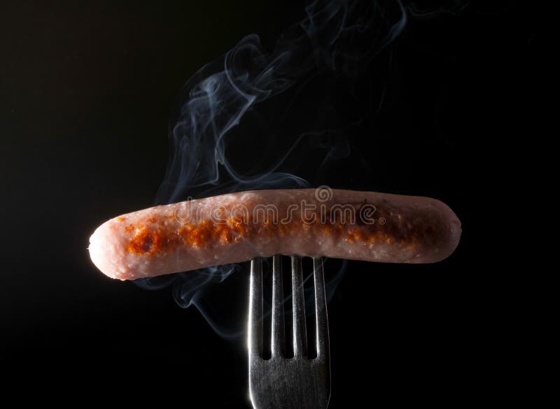 Grillad korv på en gaffel som ångar bakgrund för röksvart royaltyfria bilder Grillad korv på en gaffel som ångar bakgrund för röksvart royaltyfria bilder