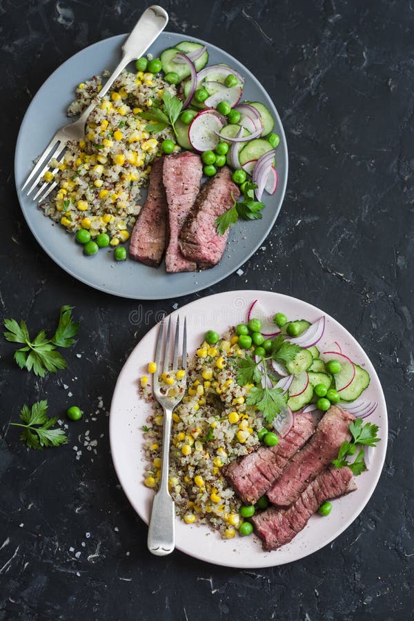 Grillad nötköttbiff och quinoahavresallad på mörk bakgrund, bästa sikt royaltyfria bilder Grillad nötköttbiff och quinoahavresallad på mörk bakgrund, bästa sikt royaltyfria bilder