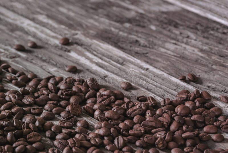 Grillade doftande kaffebönor ligger på den gamla trätexturerade tabellen Kopiera avst?nd ?ver royaltyfri foto Grillade doftande kaffebönor ligger på den gamla trätexturerade tabellen Kopiera avst?nd ?ver royaltyfri foto