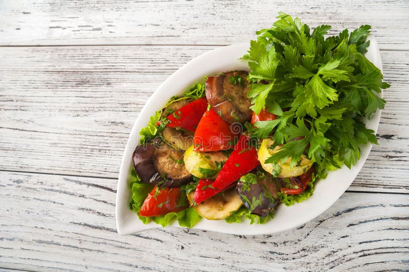 Grillade grönsaker i en vit plattanärbild Mellanmål från bakade grönsaker med Provencal örter som kopierar utrymme arkivbild Grillade grönsaker i en vit plattanärbild Mellanmål från bakade grönsaker med Provencal örter som kopierar utrymme arkivbild