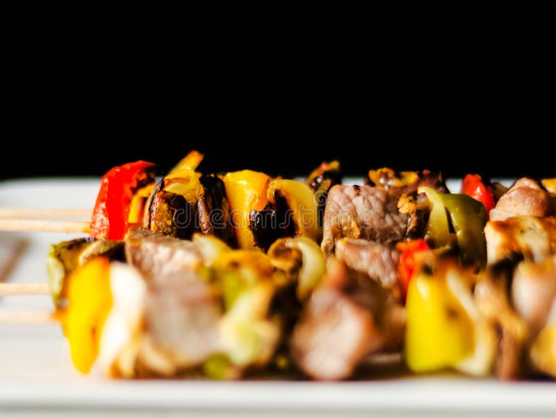 Grillade steknålar av kött och grönsaker på en träfärgrik och smaklig maträtt för bräde, royaltyfria foton Grillade steknålar av kött och grönsaker på en träfärgrik och smaklig maträtt för bräde, royaltyfria foton