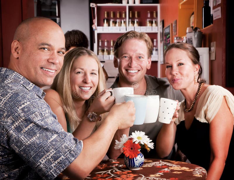 Friends in a coffee house toasting with their cups. Friends in a coffee house toasting with their cups