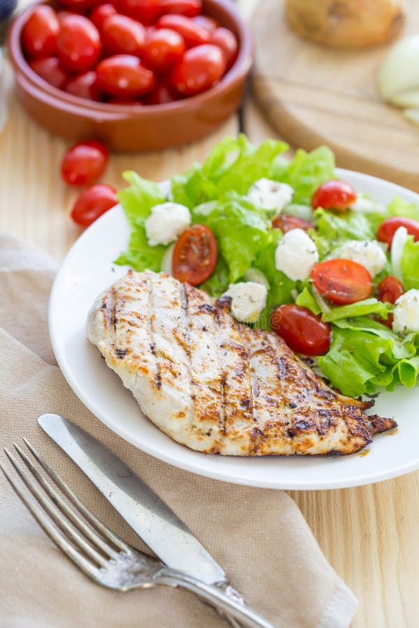Grillat fegt bröst med nya grönsaker på ljus träbakgrund arkivbilder Grillat fegt bröst med nya grönsaker på ljus träbakgrund arkivbilder