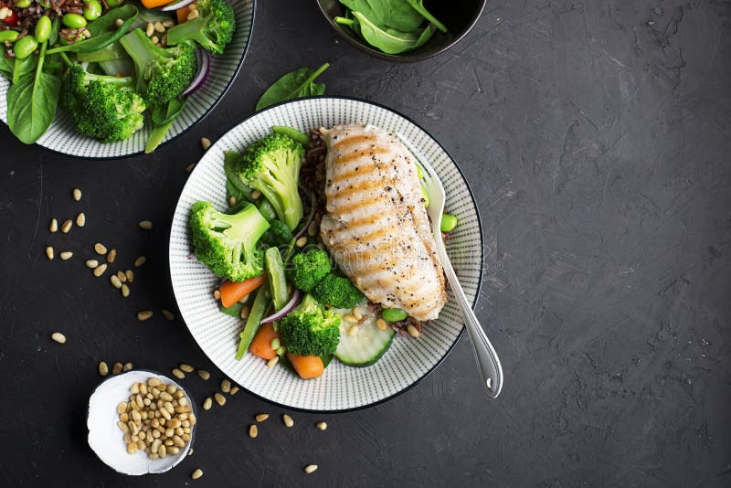 Grillat fegt bröst, röda ris och nya broccoligrönsaker, morötter, sojabönor, spenat för garnering Med sörja muttrar royaltyfri bild Grillat fegt bröst, röda ris och nya broccoligrönsaker, morötter, sojabönor, spenat för garnering Med sörja muttrar royaltyfri bild