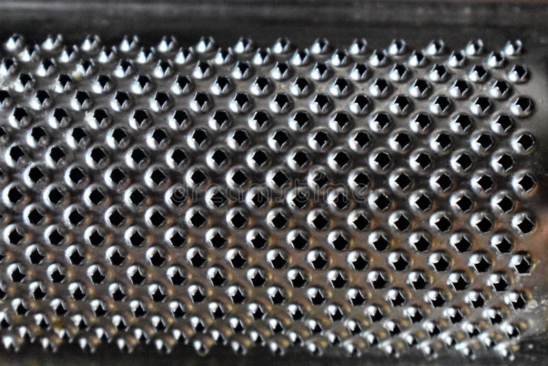 Grille de fromage en métal en gros plan. Surface d'une râpe à fromage en métal en gros plan abstrait